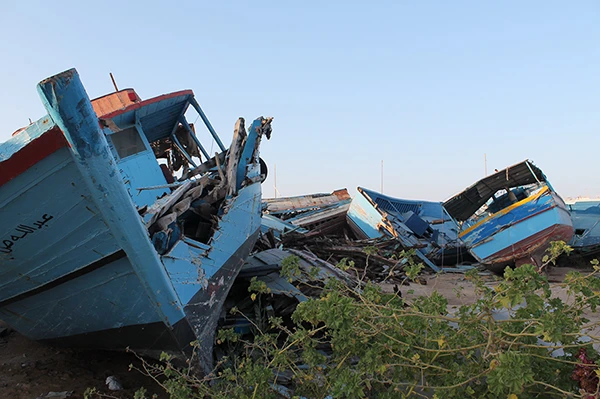 Alte Boote mit arabischen Schriftzügen und zersplittertes Holz - Schiffsfriedhof auf Lampedusa.