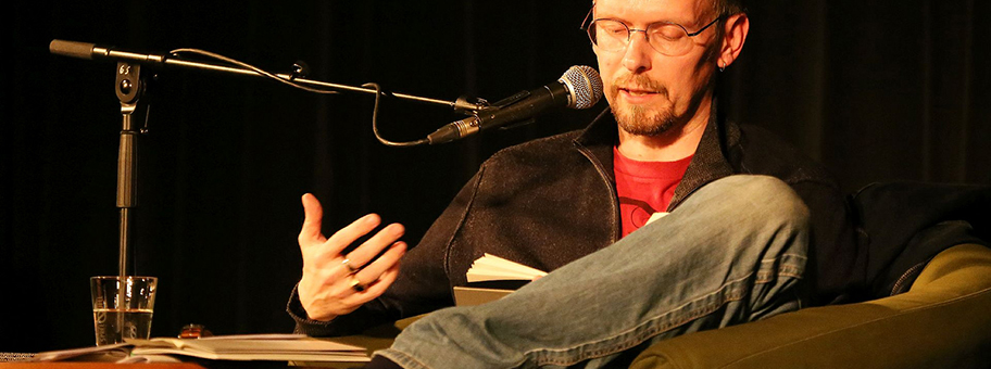 Dietmar Dath bei einer Lesung an einer Soiree in Berlin mit Kunst, Politik, Performance und Poetik.
