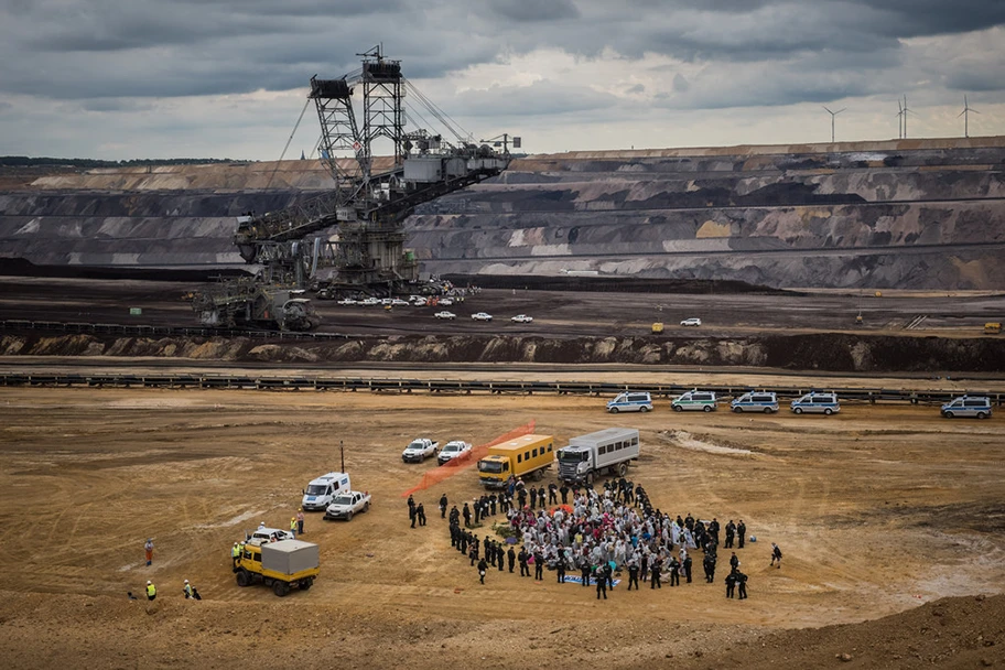 Anti-Kohle-Aktion in Garzweiler. Einsatzwagen der Polizei vor dem monströsen Kohlebagger.