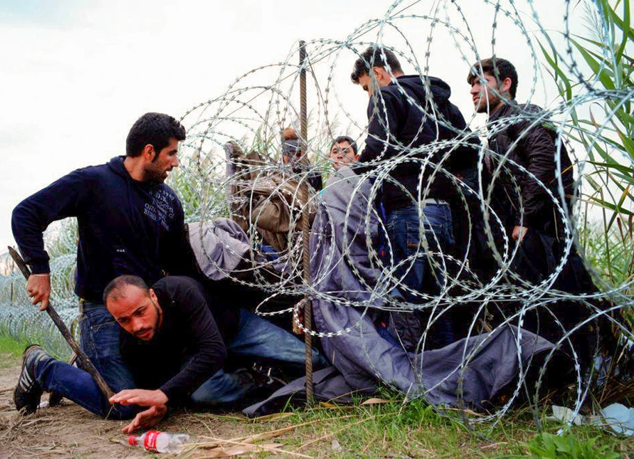 Syrische Kriegsflüchtlinge versuchen im August 2015 an der ungarischen Grenze in der Nähe von Roszke den Grenzzaun zu überwinden.