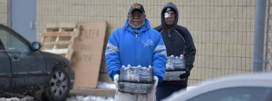 Zwei Einwohner Flints holen sich Wasserflaschen an einer Ausgabestelle.