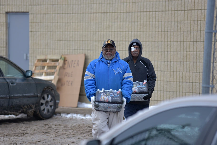 Zwei Einwohner Flints holen sich Wasserflaschen an einer Ausgabestelle.