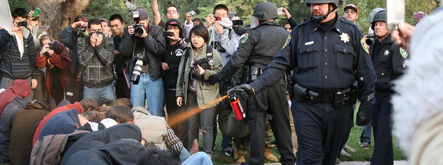 Pfeffersprayeinsatz eines kalifornischen Polizisten im Rahmen einer Sitzblockade der Studierendenprotesten der Occupy-Bewegung im November 2011.