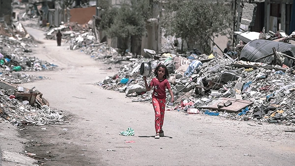 Ein Mädchen aus Gaza macht sich zu Fuss auf den Weg und trägt eine Schüssel, um während des Krieges Essen zu holen, August 2024.