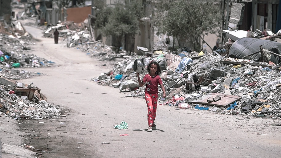 Ein Mädchen aus Gaza macht sich zu Fuss auf den Weg und trägt eine Schüssel, um während des Krieges Essen zu holen, August 2024.