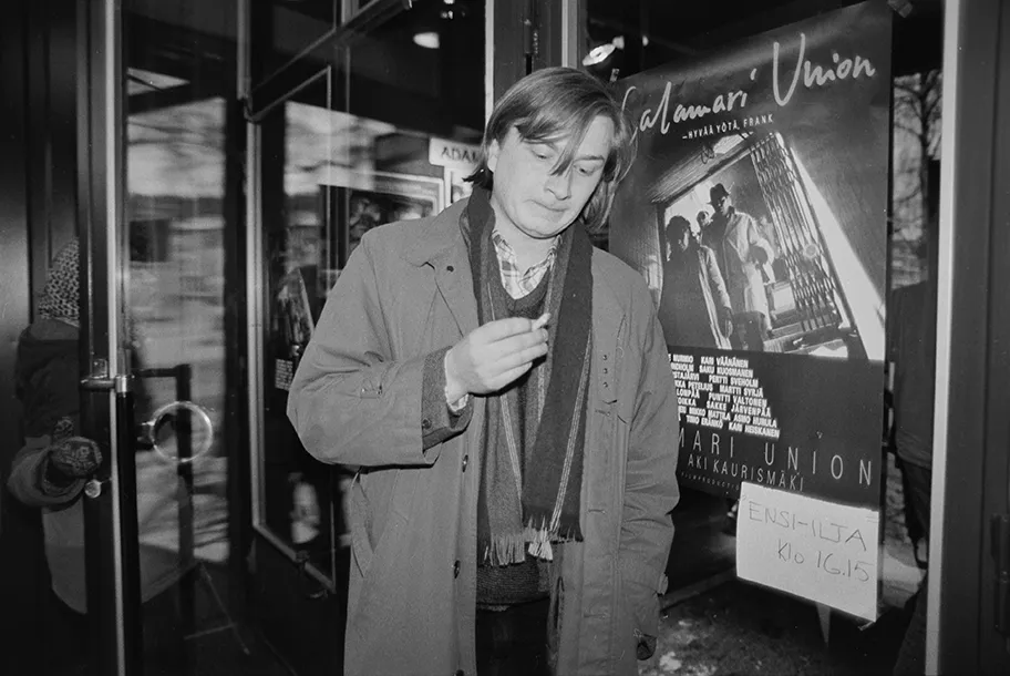 Foto des finnischen Filmregisseurs Aki Kaurismäki vor einem Filmplakat zu „Calamari Union“, Februar 1985.