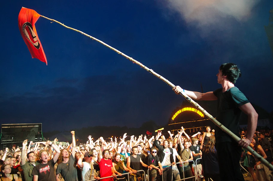 Alec Empire, Sänger von Atari Teenage Riot, mit einer Antifa Flagge am Fusion Festival 2010.