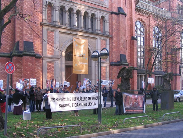 Düsseldorf, vor der Johanneskirche: Demonstrationsgruppe mit Transparent „Wir fordern die Aufklärung der Morde Sakine, Fidan und Leyla“, November 2013.
