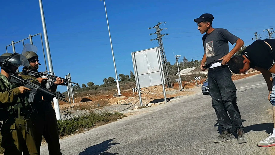 Israelische Soldaten kontrollieren zwei Palästinenser in Nabi Salih, August 2014.