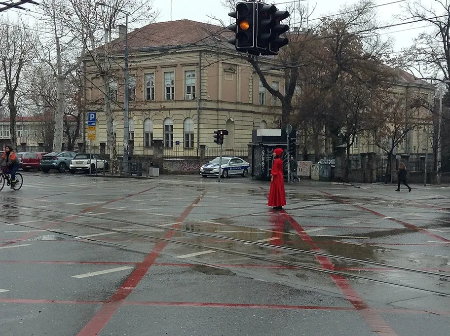 Eine Demonstrantin hält am 24. Januar 2025 um 11:52 Uhr an der Kreuzung der Straßen Takovska und Džordža Vašingtona in Belgrad den Verkehr an, um den 15 Opfern des Einsturzes des Bahnhofsvorbaus in Novi Sad zu gedenken.
