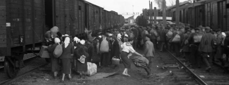 Evakuierung - Deporation [?] sowjetischer Zivilisten, Männer und Frauen beim Besteigen von Güterwagen auf einem Bahnhof.
