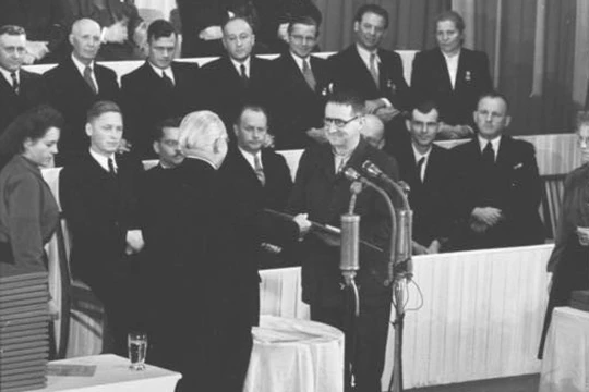 Bertolt Brecht empfängt von Präsident Wilhelm Pieck am Nationalfeiertag der DDR die Urkunde zum Nationalpreis I. Klasse.
