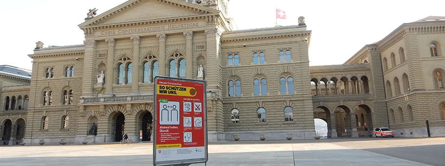 Bundeshaus Bern während COVID-19. Warntafel auf Bundesplatz, Polizeiauto und Sperrgitter Richtung Bundesterrasse.