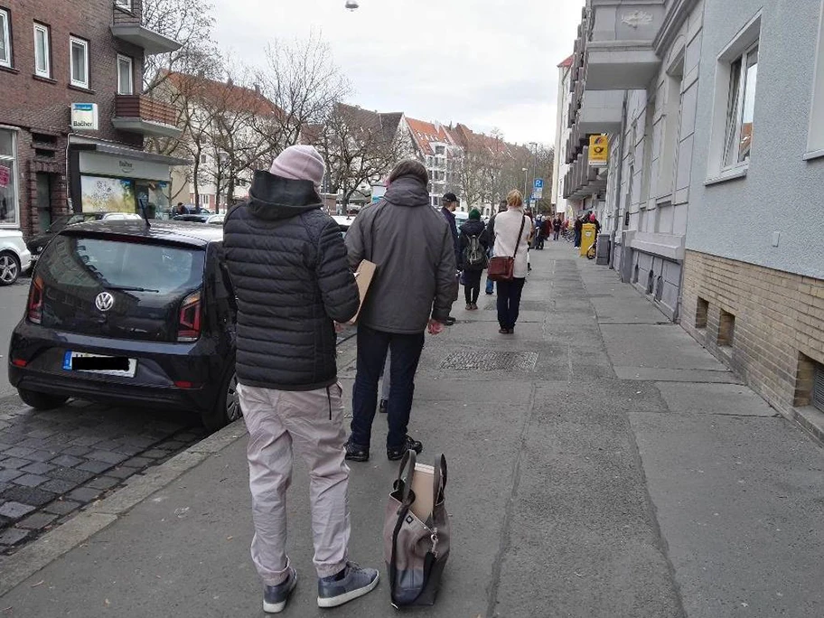 Vor der Postfiliale am Stephansplatz in Hannover warten die Menschen wegen Corona bedingter Zugangsbeschränkungen auf Einlass, Dezember 2020.