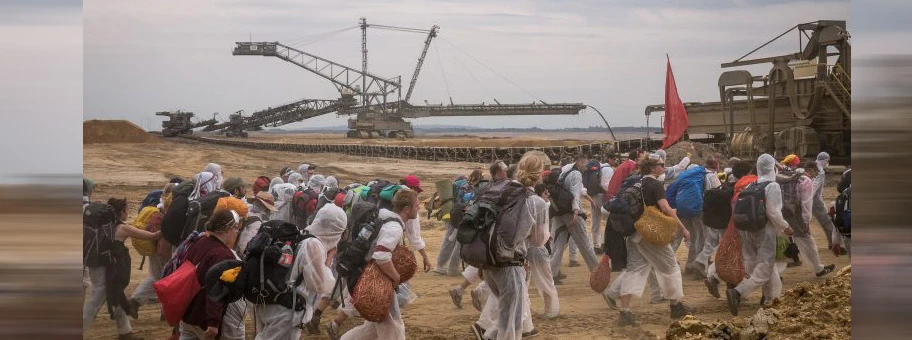 Eine Gruppe Aktivisten von Ende Gelände im Tagebau Hambach auf dem Weg in Richtung Bagger. Ein Absetzer im Hintergrund.