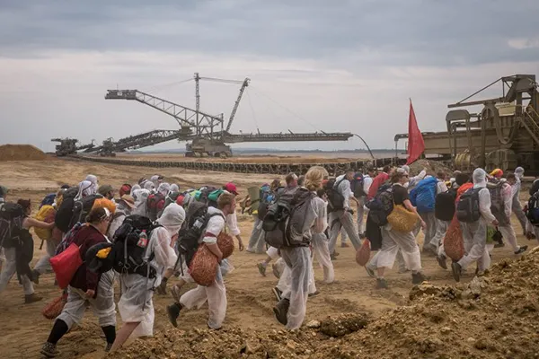 Eine Gruppe Aktivisten von Ende Gelände im Tagebau Hambach auf dem Weg in Richtung Bagger. Ein Absetzer im Hintergrund.