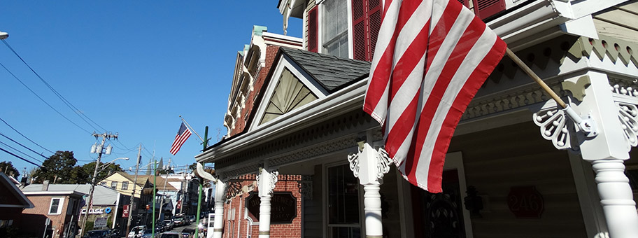 Strassenzug mit US-Flaggen in Highland Falls (West Point Military Academy), New York.