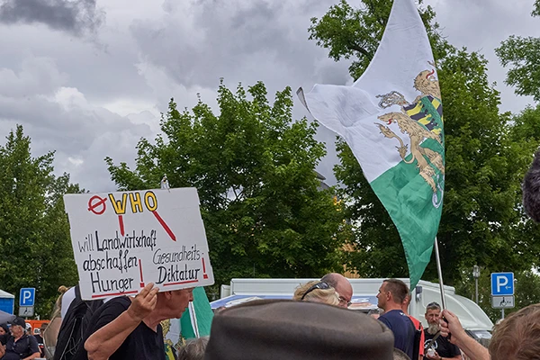 Compact-Sommerfest-Ersatzveranstaltung »WIR für Frieden und Freiheit« am 27. Juli 2024 in Gera: Anti-WHO-Schild der Freien Sachsen.
