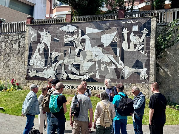 Stadtführung in Gernika vor einer Reproduktion des Picasso-Gemäldes „Guernica“.