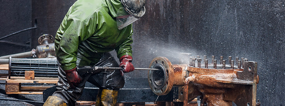 Köln, Deutschland. Industrielle Hochdruckreinigung von Druckgeräteteilen in der Chemischen Industrie mit spezieller Schutzausrüstung.
