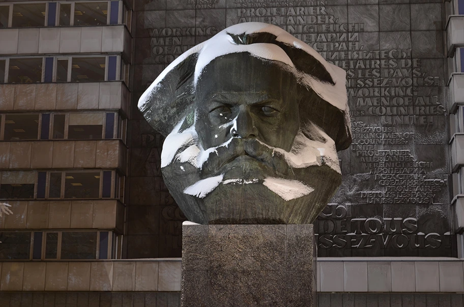 Karl Marx Monument (Nischl) in Chemnitz im Winter im Schnee in der Nacht.