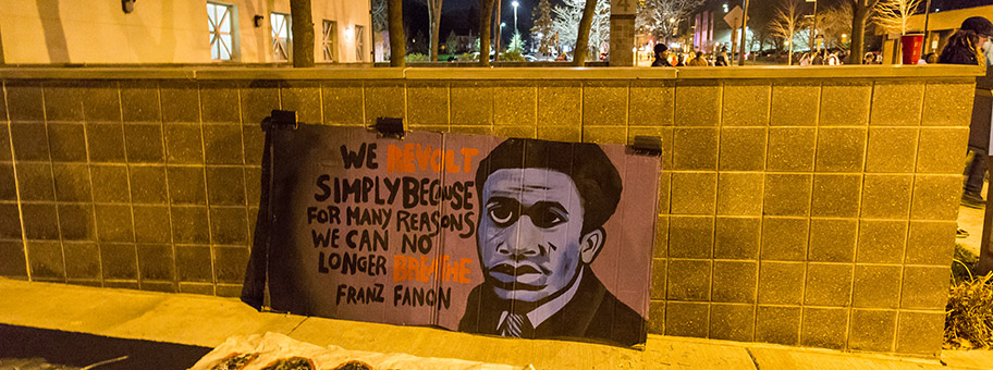 Protestschild mit Frantz Fanon-Zitat vor dem Polizeigebäude in Minneapolis, November 2015.