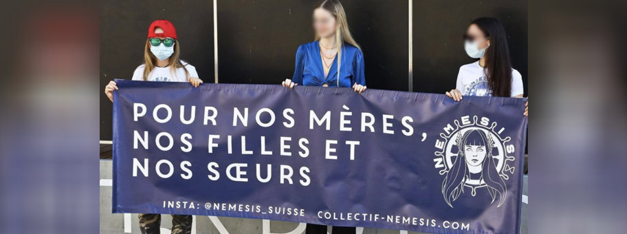 Drei Frauen von Némesis Suisse mit einem Transparent am Rande der feministischen Demo am 14. Juni 2022 in Lausanne.