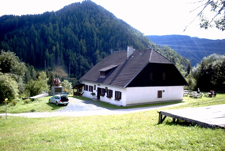 Der Persmanhof, Partisanenstützpunkt während des Krieges, Ort des Massakers vom 25. April 1945 an 4 Erwachsenen und 7 Kindern. Heute Museum mit dem Partisanendenkmal davor.