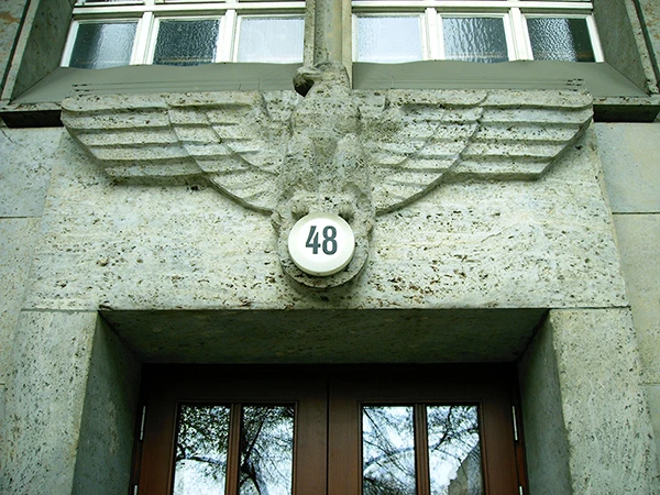 NS-Reichsadler über dem Hauptportal des Finanzamts Charlottenburg (Berlin); das Hakenkreuz an der Stelle der Hausnummer (Bismarckstrasse 48) wurde nach 1945 entfernt.