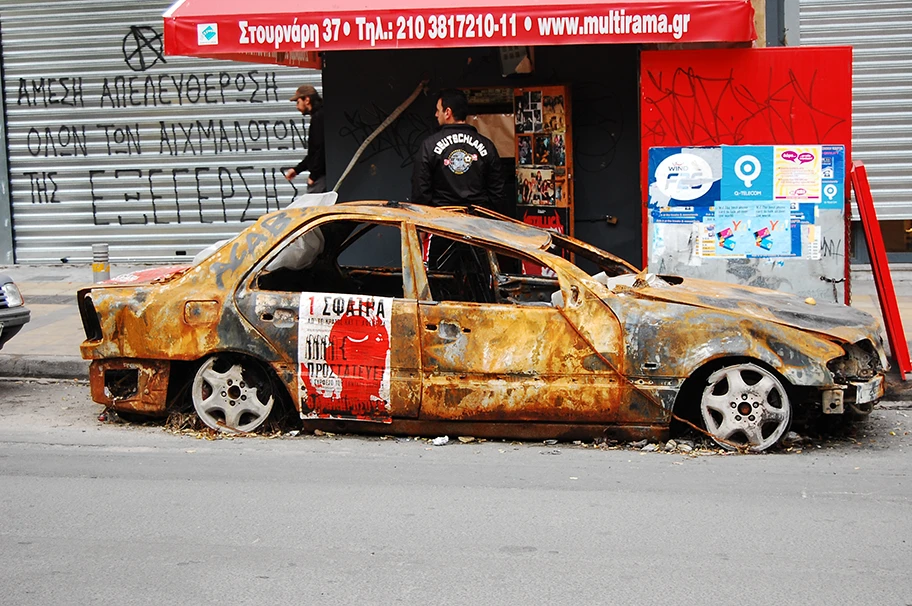 Ausgebranntes Auto nach Ausschreitungen in den Strassen von Athen.