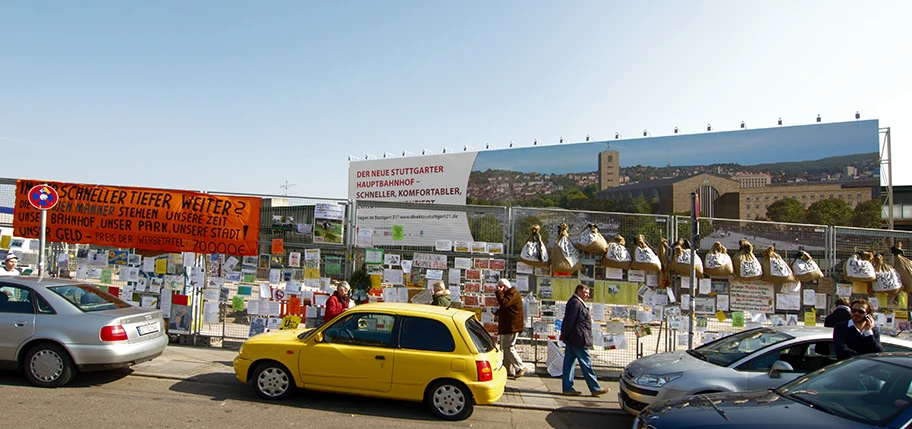 Werbeplakat für Stuttgart 21 und Protest an der Nordseite des Stuttgarter Hauptbahnhofs.