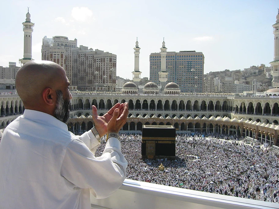 Pilger beim Bittgebet in Mekka, im Mittelgrund die Kaaba.