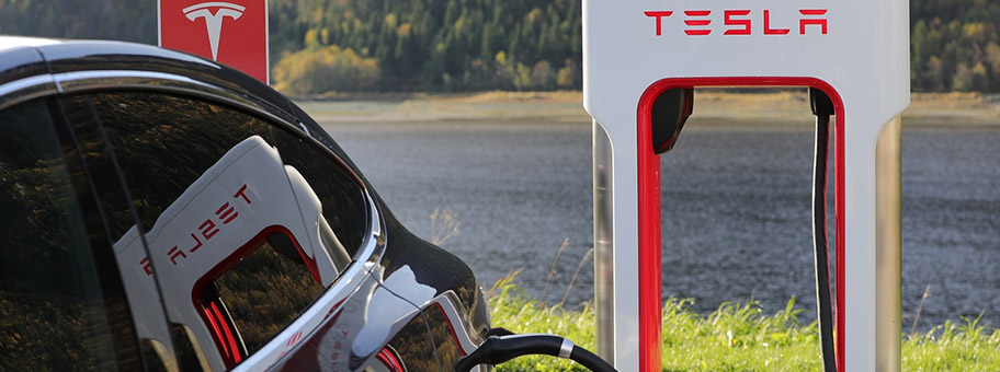 Tesla-Auto an einer elektrischen Zapfsäule.