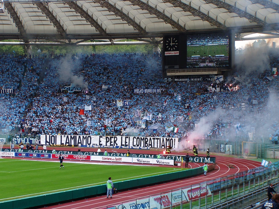 Fankurve des Lazio Rom bei einem Heimspiel. Die Ultragruppierung «Irriducibili Lazio» ist bekannt dafür, dass sie sich offen zum Faschismus bekennt. Lazio wurde vom italienischen Verband deswegen schon mehrfach mit Platzsperren oder Spielen unter Ausschluss der Öffentlichkeit bestraft.