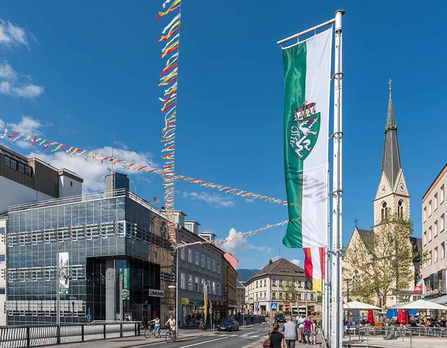 Bahnhofstrasse mit dem Gebäude der Bank Austria Creditanstalt und der Nikolaiplatz mit der Nikolaikirche, Stataturstadt Villach, Kärnten, Österreich.