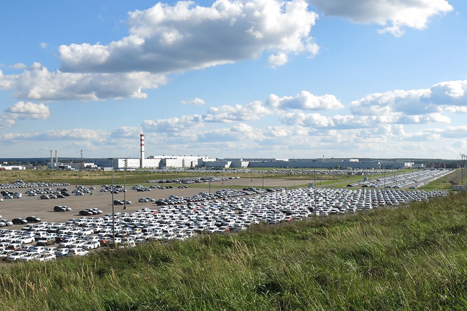 Blick auf das Volkswagenwerk bei Kaluga. Im Vordergrund auf der Abstellfläche stehen neben Fahrzeugen der Typen Amarok, Caddy, Polo und Tiguan auch Audi- und Skoda-Modelle.