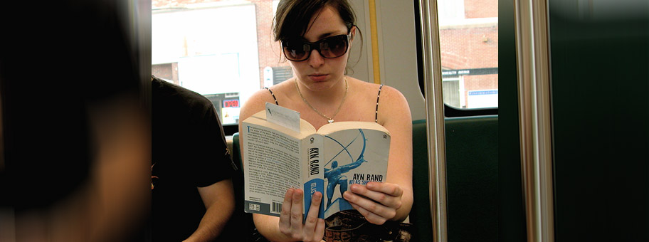 Eine junge Frau in der S-Bahn von Boston mit einem Buch von Ayn Rand.