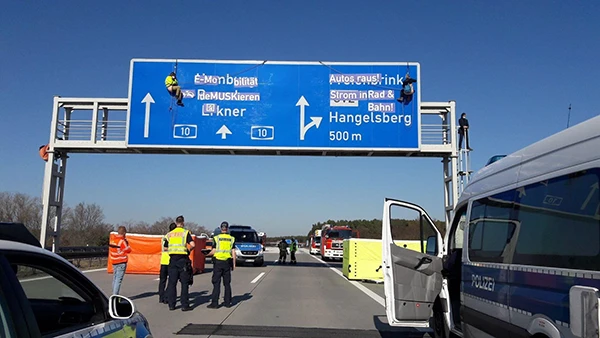 Aktivist:innen stoppen den Verkehr auf der Autobahn am Tesla Werk bei Berlin. Unter dem Motto "E-Mobilität demuskieren" fordern sie die sofortige Subventionierung von E-Bussen und E-Fahrrädern statt E+ Autos.