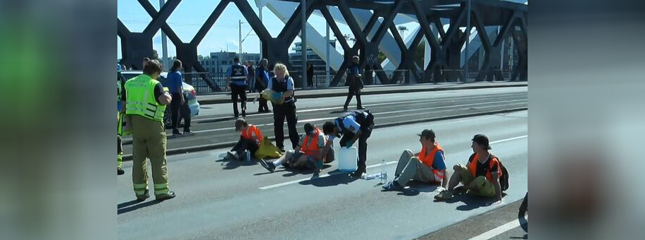 Sitzblockade in Mannheim am 6. September 2023 auf der Konrad-Adenauer-Brücke. Polizistin schüttet Pflanzenöl über Demonstrantin.