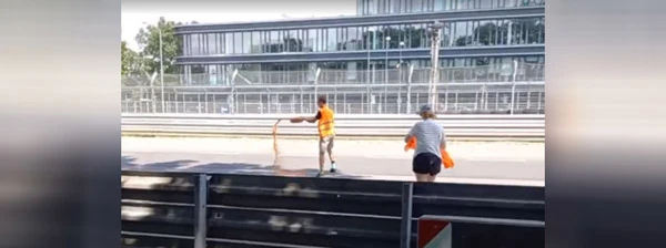 Unterstützer der Letzten Generation vergiesst Öl auf der Rennstrecke.