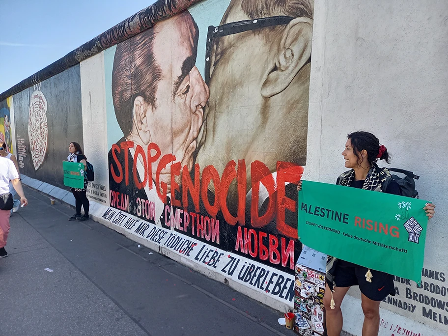 Mit einem Protest an der East Side Gallery in Berlin (siehe oben) haben zwei Unterstützerinnen der Neuen Generation eine klare Botschaft an unsere Bundesregierung (die Waffen an Israel liefert) und die internationale Gemeinschaft gesendet.
