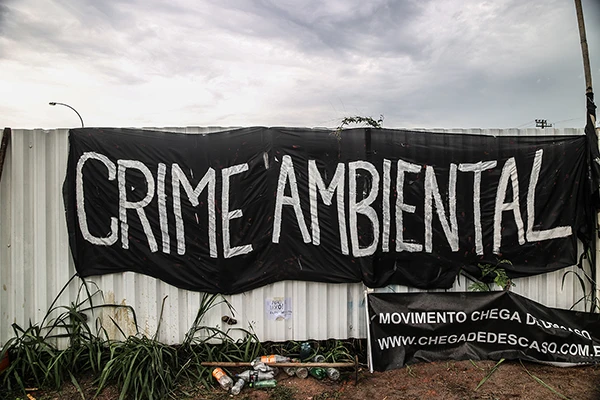Protestplakat mit dem Titel „Umweltverbrechen“ vor dem eigens für die Olympischen Spiele angelegten Golfplatz in Rio de Janeiro.
