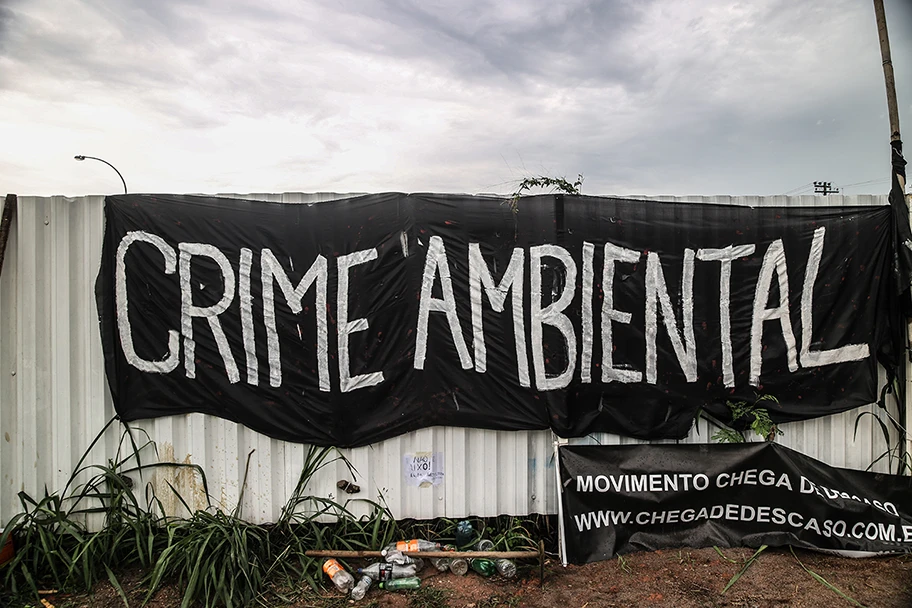 Protestplakat mit dem Titel „Umweltverbrechen“ vor dem eigens für die Olympischen Spiele angelegten Golfplatz in Rio de Janeiro.